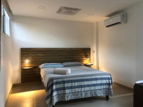 a bedroom with a bed with a wooden headboard at Cabañas Annapurna in Taganga