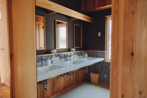a bathroom with two sinks and two windows at Cider Barn &more in Iida