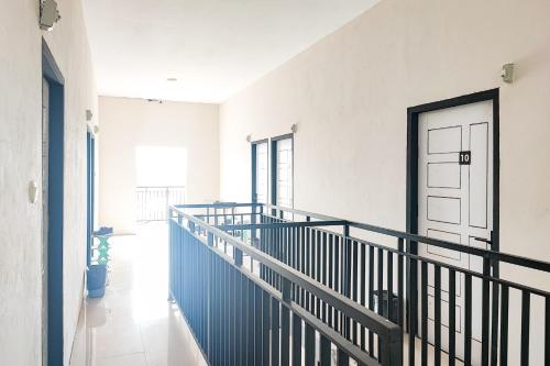 a hallway with a staircase with a blue door at RedDoorz Syariah near Universitas Jambi Telanaipura in Jambi