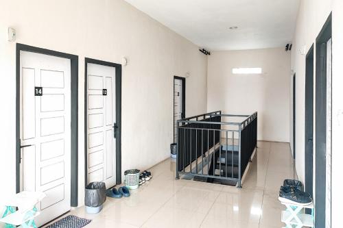 a room with two white doors and some shoes on the floor at RedDoorz Syariah near Universitas Jambi Telanaipura in Jambi
