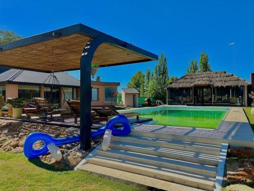 una piscina con un tobogán azul junto a una casa en Casona Valdivia en San Rafael en San Rafael