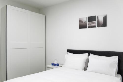 a bedroom with a white bed with white pillows at Luxury Family Apartment #26 By Hashdera Eilat in Eilat