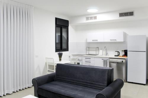 a living room with a couch and a kitchen at Luxury Family Apartment #26 By Hashdera Eilat in Eilat