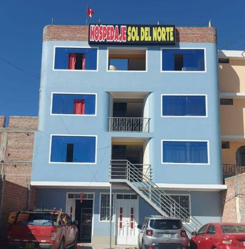 een wit gebouw met een bord erop bij HOSPEDAJE SOL DEL NORTE in Ayacucho