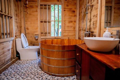 a bathroom with a tub and a toilet and a sink at La Vie En Rose Ba Vì Homestay in Hanoi