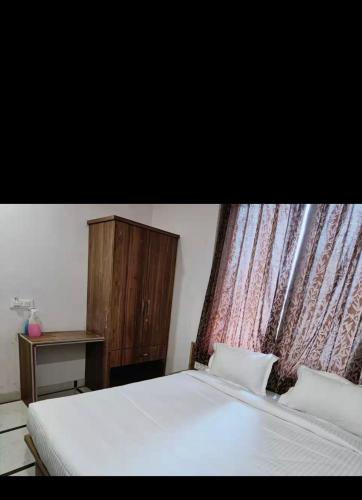 1 dormitorio con cama blanca y armario de madera en Hotel mansi palace en Udaipur