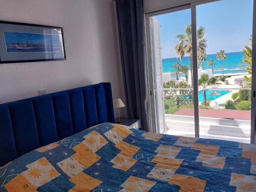 a bedroom with a bed and a view of the ocean at Villa Margo by the Sea in Paphos City
