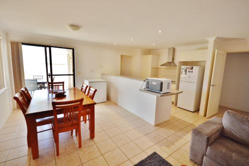 a kitchen and dining room with a table and a microwave at Surfside Retreat - Kalbarri WA in Kalbarri