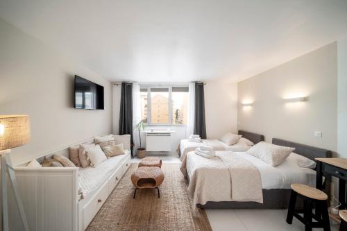 - une chambre blanche avec 2 lits et un canapé dans l'établissement Cosy Studio located 2 minutes from the famous Croisette, à Cannes