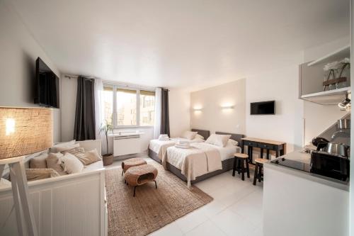 Il comprend un salon blanc avec un lit et une cuisine. dans l'établissement Cosy Studio located 2 minutes from the famous Croisette, à Cannes