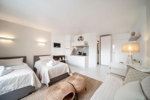 - une chambre blanche avec 2 lits et un canapé dans l'établissement Cosy Studio located 2 minutes from the famous Croisette, à Cannes