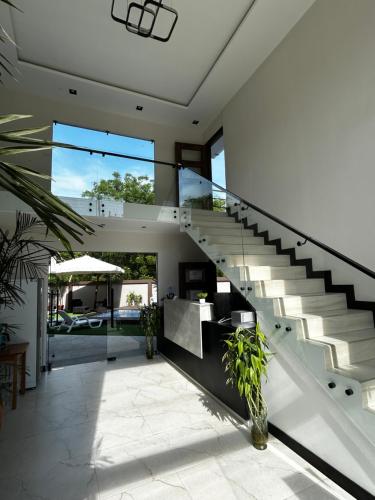 a staircase in a house with glass railing at OCEAN DRIVE LODGE in Montañita