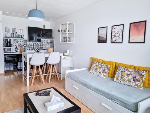 un salon avec un canapé et une cuisine dans l'établissement Appartement 200m de la plage, 4 couchages, parking privé - FR-1-746-19, à Courseulles-sur-Mer