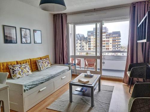 un salon avec un canapé et une grande fenêtre dans l'établissement Appartement 200m de la plage, 4 couchages, parking privé - FR-1-746-19, à Courseulles-sur-Mer