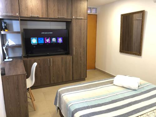 Habitación con TV de pantalla plana y cama. en Cabañas Annapurna en Taganga