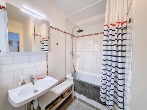 La salle de bains blanche est pourvue d'un lavabo et d'une baignoire. dans l'établissement Appartement 200m de la plage, 4 couchages, parking privé - FR-1-746-19, à Courseulles-sur-Mer