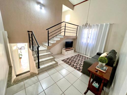 a living room with a staircase and a couch at Casa com ótima localização in Piracicaba