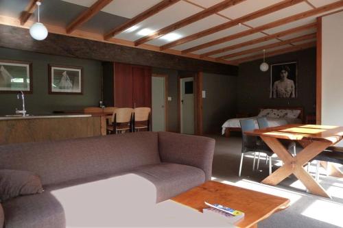 a living room with a couch and a table at Leigh Sawmill Accomodation in Leigh