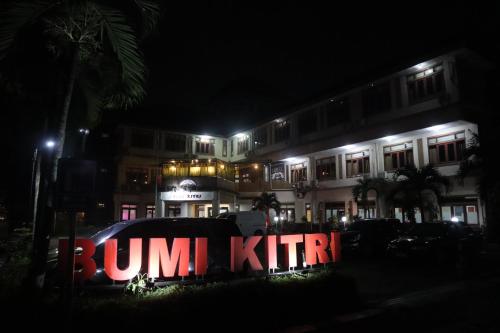 a building with a sign in front of it at night at Hotel Bumi Kitri in Bandung