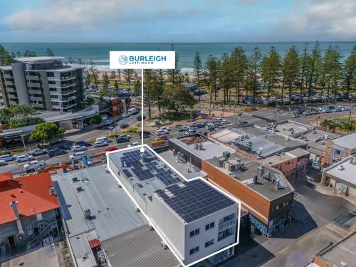 an aerial view of a city with a building with solar panels at The Laneway Villas by Burleigh Letting Company in Gold Coast