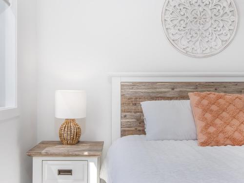 a bedroom with a bed with a wooden headboard and a lamp at The Laneway Villas by Burleigh Letting Company in Gold Coast