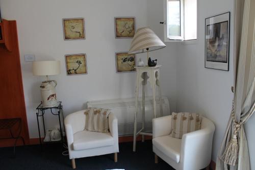 a room with two chairs and a table and a lamp at Logis-Hôtel Côté-Rivage in Badefols-sur-Dordogne