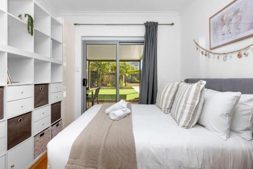 a bedroom with a bed and a sliding glass door at Maylands Coastal Vibes in Perth