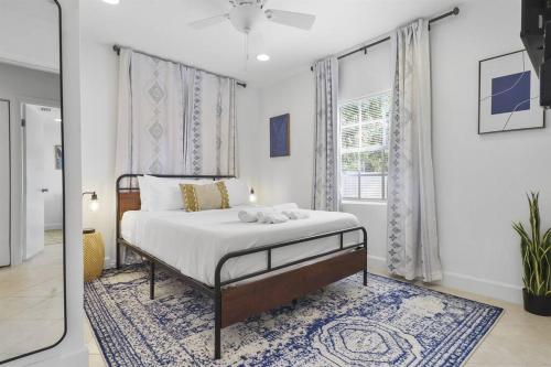 a bedroom with a bed and a window at Palm Wave Says - Quiet House in Best Area in West Palm Beach