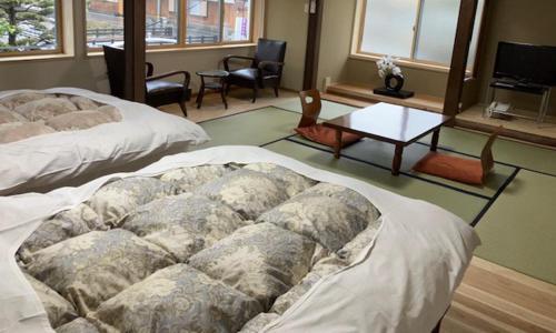 Wakariki Ryokan tesisinde bir odada yatak veya yataklar