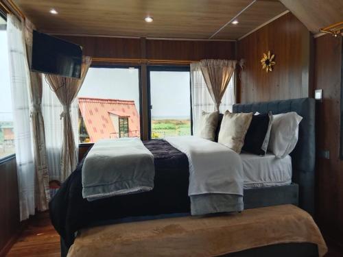 a bedroom with a large bed with a large window at El Encanto de Tota los Pensamientos in Tota