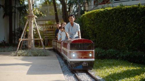 a group of people riding on a small train at InterContinental Hua Hin Resort, an IHG Hotel in Hua Hin