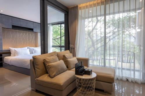 - une chambre avec un canapé, un lit et une fenêtre dans l'établissement Luxury Resort City Gate Kamala C33, à Kamala Beach