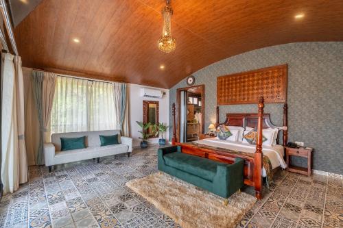 a large bedroom with a bed and a couch at Simroseate in Agonda