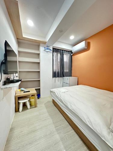 - une chambre avec un lit et une télévision dans l'établissement FunSong逢甲, à Taichung