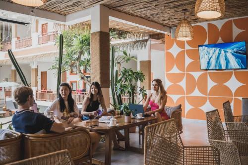 un gruppo di persone sedute a un tavolo in un ristorante di Roomates Hostel Canggu by Ini Vie Hospitality a Canggu