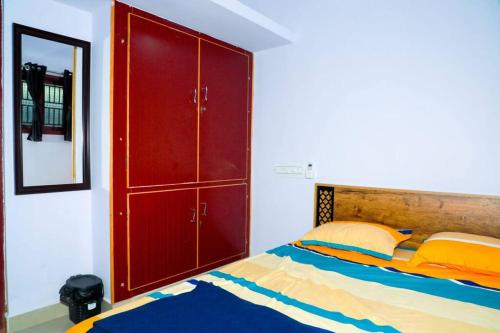 1 dormitorio con 1 cama y armario rojo en The Peaceful place en Kāraikkudi