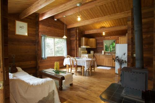 a living room with a table and a kitchen at The Cabins at Kokee in Waimea
