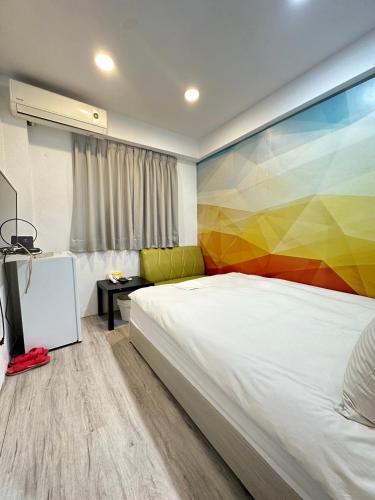 a bedroom with a bed with a colorful wall at FunSong逢甲 in Taichung