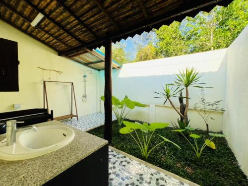 baño con lavabo y jardín en Phước Lạc Duyên Garden House by ACC, en Ấp Thanh Sơn (1)