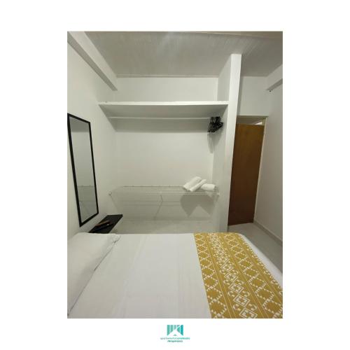 een witte badkamer met een spiegel en een tapijt bij Mi Esperanza in Villavicencio