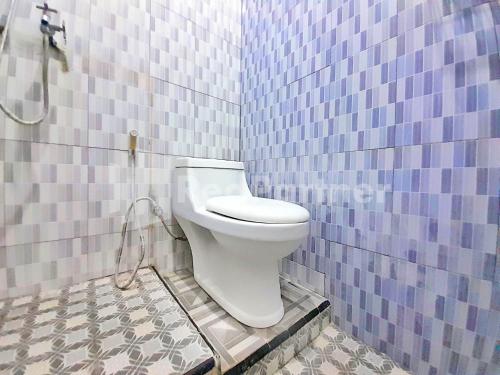 a bathroom with a toilet in a blue tiled wall at LH101 Guest House Syariah near Makam Sunan Bonang RedPartner in Tuban