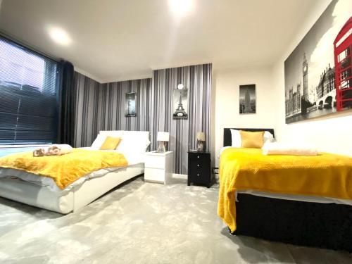 two beds in a bedroom with yellow and white at Leeds City House in Leeds