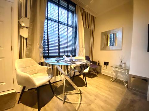 a living room with a table and chairs and a window at Leeds City House in Leeds