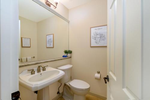 a white bathroom with a sink and a toilet at Fairways402 in Waikoloa