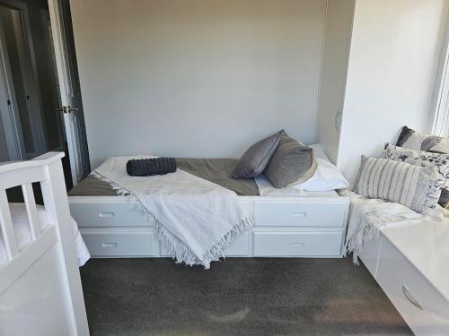 a white bed with pillows on it in a room at Legana Lodge - A home away from home - Catering for up to 12 guests in Legana
