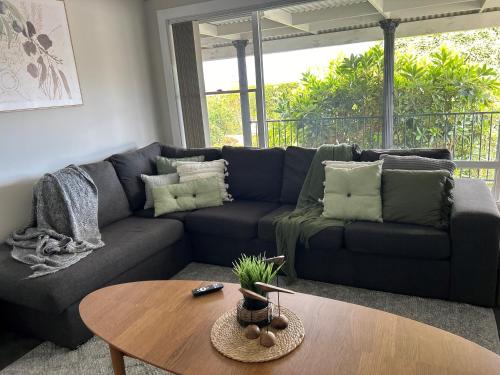 a living room with a couch and a table at Legana Lodge - A home away from home - Catering for up to 12 guests in Legana