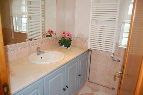 a bathroom with a sink and a mirror at Villa Monte Alegrete with sea view in Santa Bárbara de Nexe