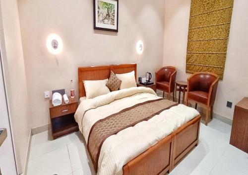 a bedroom with a large bed and two chairs at Cordial Hotels And Resorts Private Limited in Sītāpur