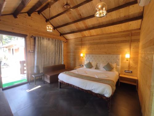 a bedroom with a large bed in a wooden room at Cocorico Beach Resort in Dapoli