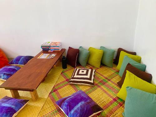 a room with colorful pillows and a wooden table at Jaydy hostel in General Luna